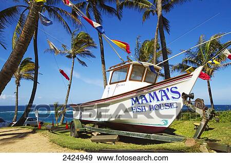 Stock Photo - Hawaii, Maui, A fishing boat in front of Mama's Fish House restaurant on the north shore. EDITORIAL USE ONLY.. Fotosearch