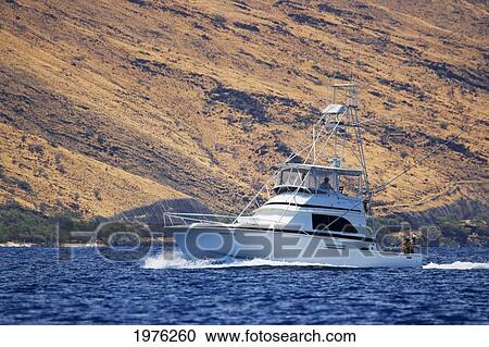 Stock Image - Hawaii, Maui, A Sportfishing Boat Cruises In Blue Ocean Water.. Fotosearch
