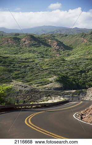 Stock Photo - Hawaii, Maui, A winding road through Maui's west side with lush mountains.. Fotosearch