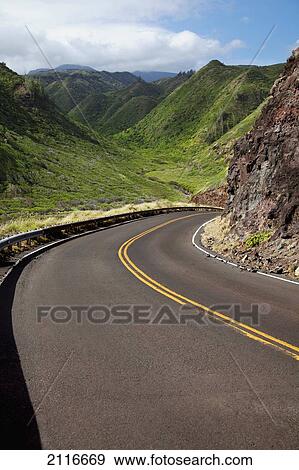 Stock Photo - Hawaii, Maui, A winding road through Maui's west side with lush mountains.. Fotosearch