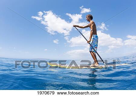 Stock Photo - Hawaii, Maui, Athletic Young Man On A Stand Up Paddle Board. Fotosearch