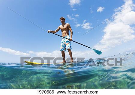 Stock Photograph - Hawaii, Maui, Athletic Young Man On A Stand Up Paddle Board. Fotosearch