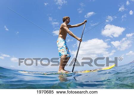 Stock Photography - Hawaii, Maui, Athletic Young Man On A Stand Up Paddle Board. Fotosearch