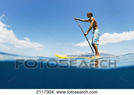 Picture - Hawaii, Maui, Athletic young man on stand up paddle board.. Fotosearch