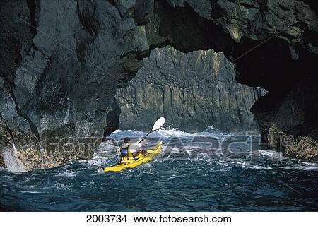 Picture - Hawaii, Maui, Back View Of Man Sea Kayaking Through Natural Arch Near Keanae, Rough. Fotosearch