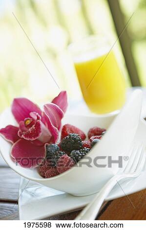 Stock Photo - Hawaii, Maui, Balcony, Breakfast Fresh Fruit Bowl With Orange Juice And Orchid Garnish.. Fotosearch