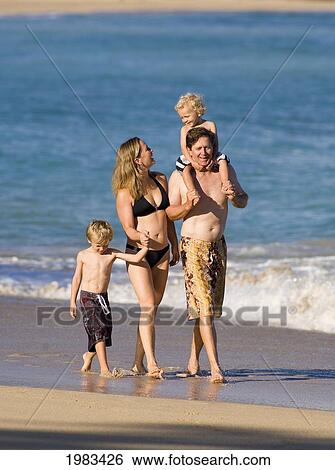 Stock Photograph - Hawaii, Maui, Baldwin Beach, A Young Family Walking Along The Waters Edge.. Fotosearch
