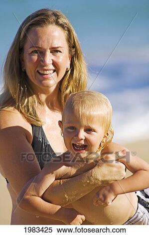 Stock Photography - Hawaii, Maui, Baldwin Beach, Mother And Son Playing At The Waters Edge.. Fotosearch