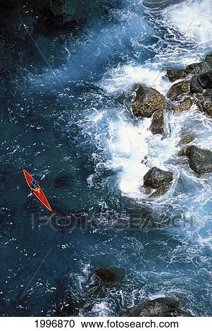 Stock Image - Hawaii, Maui, Distant View From Above Man Kayaking Along Coast, Turbulent Ocean. Fotosearch