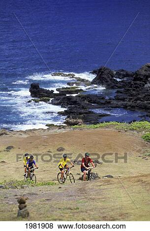 Stock Photo - Hawaii, Maui, group of people mountain biking above the ocean in the North.. Fotosearch