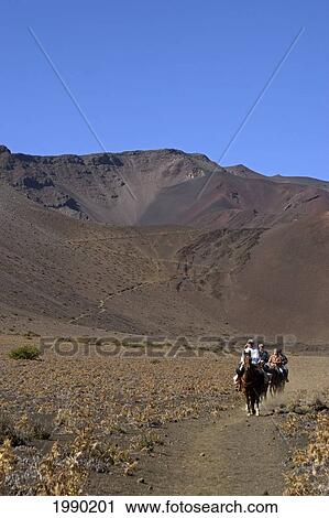 Stock Image - Hawaii, Maui, Haleakala Crater, Horseback Riders Crossing The Crater Floor. Fotosearch