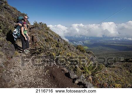 Stock Photograph - Hawaii, Maui, Haleakala Crater, Two hikers pose while trekking up the switchbacks of the trail.. Fotosearch
