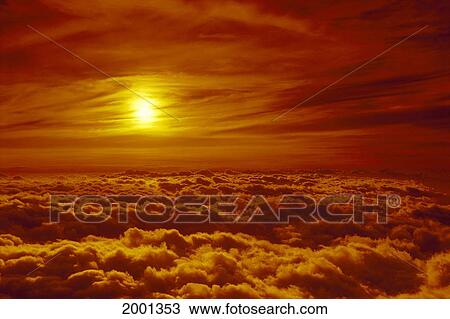 Stock Image - Hawaii, Maui, Haleakala National Park Sunset Orange Wispy Clouds Surround Sun Puffy Layer Thick Clouds. Fotosearch