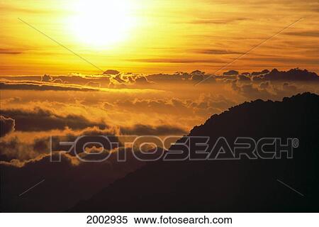 Hawaii, Maui, Haleakala National Park, Winter Sunrise Glowing In Orange Streaked Sky, Above Clouds View Large Photo Image Stock Photography - Hawaii, Maui, Haleakala National Park, Winter Sunrise Glowing In Orange Streaked Sky, Above Clouds. Fotosearch