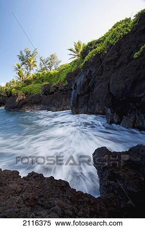 Stock Photography - Hawaii, Maui, Hana, The rocky coastline of Waianapanapa showing the movement of the water.. Fotosearch