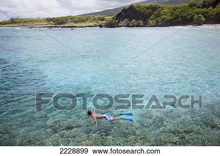 Stock Photo - Hawaii, Maui, Hana, Vacationing Man Snorkels Along Coastline, Coral Seen Through Crystal Clear Water.. Fotosearch