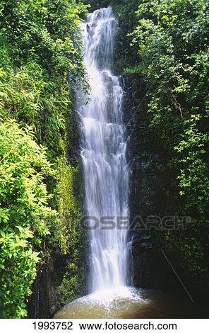 Stock Image - Hawaii, Maui, Hana, Wailua Falls Valley, Waterfall Surrounded By Lush Greenery. Fotosearch
