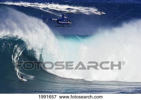 Hawaii, Maui, Helicopter Filming Tow-In Surfer At Peahi Aka Jaws, Wild Crashing Waves. View Large Photo Image Stock Photo - Hawaii, Maui, Helicopter Filming Tow-In Surfer At Peahi Aka Jaws, Wild Crashing Waves.. Fotosearch