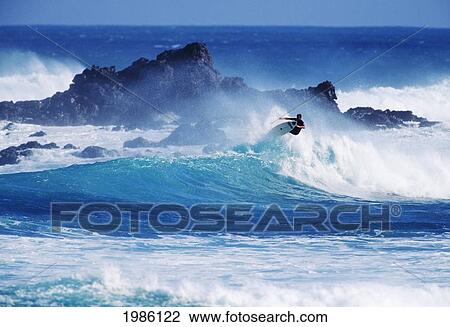 Stock Image - Hawaii, Maui, Hookipa Beach Park, Pavillions, Surfer Grabbing Board While Riding Wave.. Fotosearch