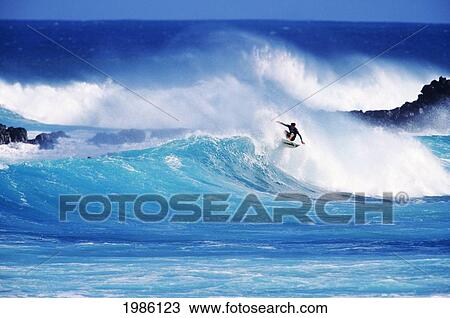 Stock Image - Hawaii, Maui, Hookipa Beach Park, Pavillions, Surfer Riding Crashing Wave.. Fotosearch