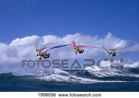 Stock Photo - Hawaii, Maui, Ho'okipa, Three Airborne Windsurfers Off The Lip, Clouds Background. Fotosearch