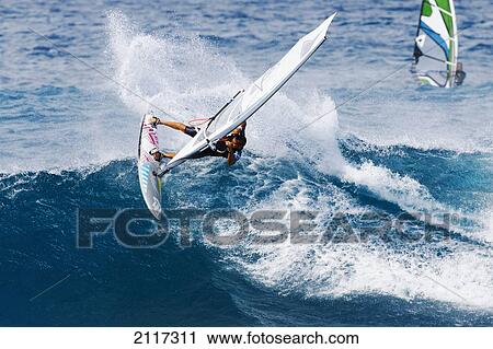 Stock Image - Hawaii, Maui, Ho'okipa, Windsurfer carves a big turn on wave Peahi, also know as Jaws. EDITORIAL USE ONLY.. Fotosearch