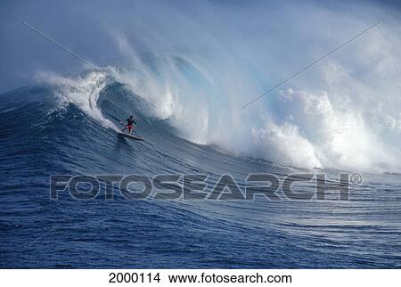 Picture - Hawaii, Maui, Jaws, Sierra Emory Rides Huge Crashing Wave In Distance. Fotosearch