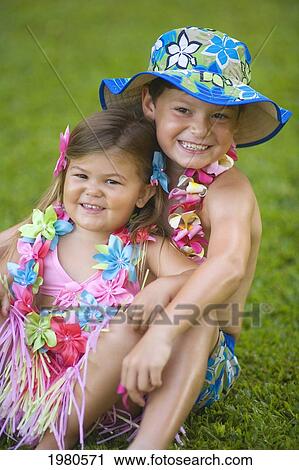 Stock Image - Hawaii, Maui, Kaanapali, Young Boy And Girl Sit On Grass In Park.. Fotosearch