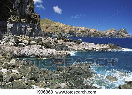 Stock Photo - Hawaii, Maui, Kahakuloa, Distant View Two Men Kayaking Along Coast, Blue Sky Background. Fotosearch