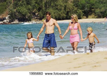 Stock Image - Hawaii, Maui, Kapalua, Fleming Beach, Family On Vacation Walking Down The Beach.. Fotosearch