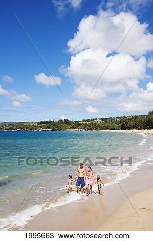 Stock Image - Hawaii, Maui, Kapalua, Fleming Beach, Family On Vacation Walking Down The Beach.. Fotosearch