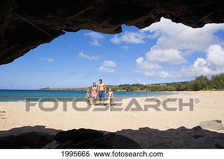 Stock Photography - Hawaii, Maui, Kapalua, Fleming Beach, Family On Vacation Walking Down The Beach, View From Seacave. Fotosearch
