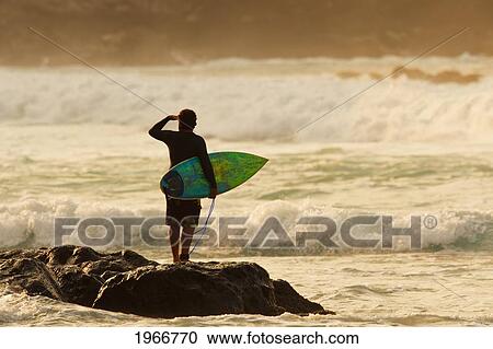 Stock Image - Hawaii, Maui, Kapalua, Local Surfer Standing On A Rock Checking The Waves. Fotosearch