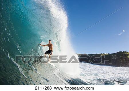 Stock Photo - Hawaii, Maui, Kapalua, Surfer rides a wave at Honolua Bay. EDITORIAL USE ONLY.. Fotosearch