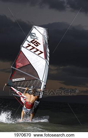 Stock Image - Hawaii, Maui, Kihei, Professional Windsurfer Dean Christener Sailing At Sunset. For Editorial Use Only.. Fotosearch