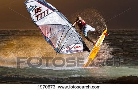 Stock Image - Hawaii, Maui, Kihei, Professional Windsurfer Dean Christener Sailing At Sunset. For Editorial Use Only.. Fotosearch