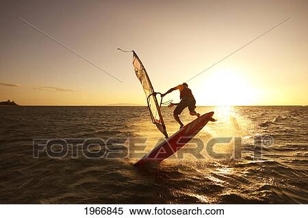 Stock Photography - Hawaii, Maui, Kihei, Windsurfer Sailing Off The Coast Of South Maui At Sunset. Fotosearch