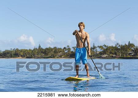 Hawaii, Maui, Kihei, Young man Stand Up Paddling in the ocean on sunny day. View Large Photo Image Stock Image - Hawaii, Maui, Kihei, Young man Stand Up Paddling in the ocean on sunny day.. Fotosearch
