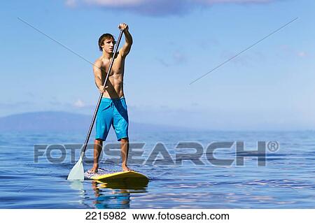 Hawaii, Maui, Kihei, Young man Stand Up Paddling in the ocean on sunny day. View Large Photo Image Stock Image - Hawaii, Maui, Kihei, Young man Stand Up Paddling in the ocean on sunny day.. Fotosearch