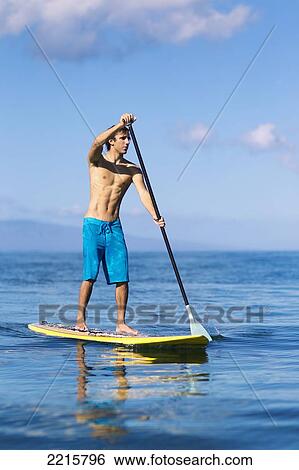 Hawaii, Maui, Kihei, Young man Stand Up Paddling in the ocean on sunny day. View Large Photo Image Stock Photograph - Hawaii, Maui, Kihei, Young man Stand Up Paddling in the ocean on sunny day.. Fotosearch