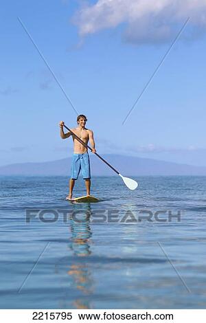 Stock Photography - Hawaii, Maui, Kihei, Young man Stand Up Paddling in the ocean on sunny day.. Fotosearch