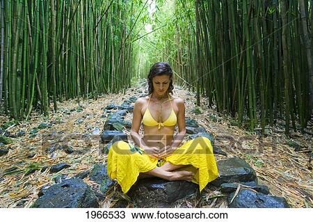 Stock Image - Hawaii, Maui, Kipahulu, Woman Meditating In Bamboo Forest.. Fotosearch