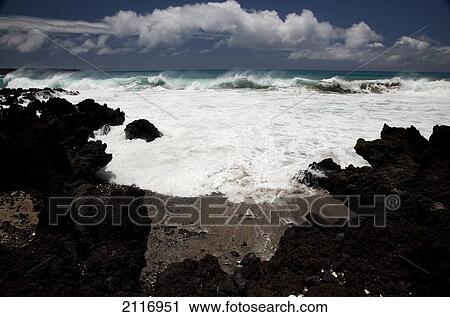 Stock Image - Hawaii, Maui, La Perouse, A wave breaks with lave rocks in the foreground.. Fotosearch
