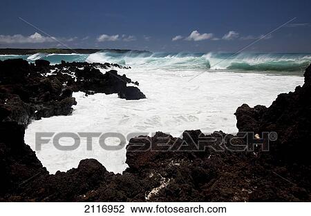 Stock Image - Hawaii, Maui, La Perouse, A wave breaks with lave rocks in the foreground.. Fotosearch