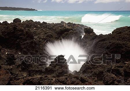 Stock Image - Hawaii, Maui, La Perouse Bay, A burst of water through a blowhole in some lava rocks.. Fotosearch