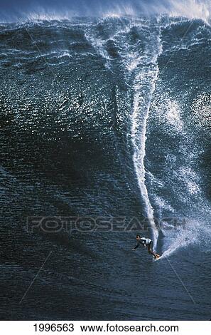 Stock Image - Hawaii, Maui, Long Shot Michelle Larronde Peahi Surfing Jaws (Huge Dark Blue Wave).. Fotosearch