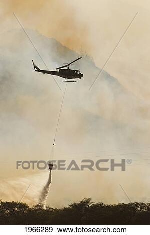 Stock Photo - Hawaii, Maui, Ma'alaea, Fire Helicopter Dropping Ocean Water On Wildfire. Editorial Use Only.. Fotosearch