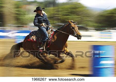 Stock Photo - Hawaii, Maui, Makawao, Cowgirl Barrel Racing In 2010 4Th Of July Makawao Rodeo, Blurred Action. Editorial Use Only.. Fotosearch