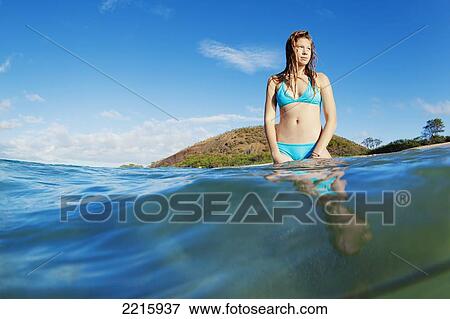Stock Photo - Hawaii, Maui, Makena Beach, A young woman enjoys taking a dip in the ocean on a sunny day.. Fotosearch