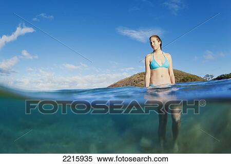 Stock Photography - Hawaii, Maui, Makena Beach, A young woman enjoys taking a dip in the ocean on a sunny day.. Fotosearch